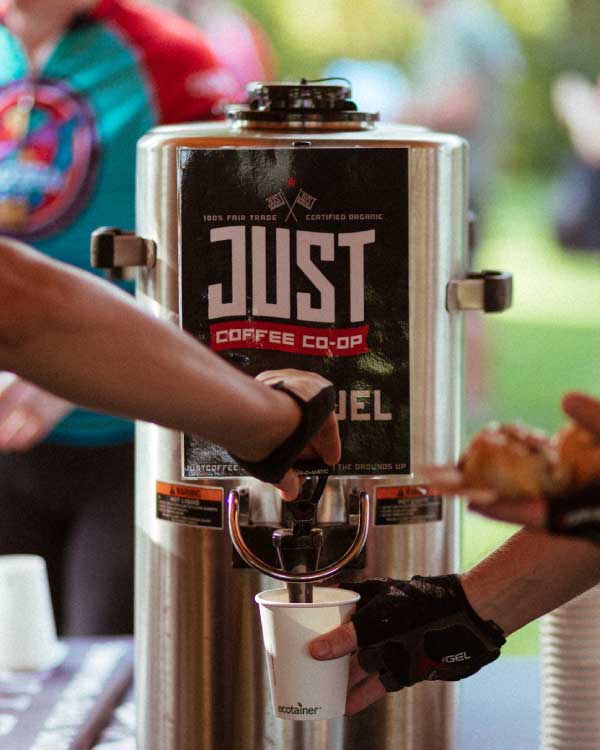 Large coffee server dispensing coffee in paper cup 